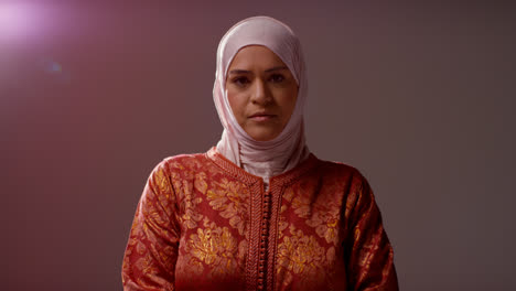 Studioporträt-Einer-Muslimischen-Frau-Mit-Hijab-Vor-Schlichtem,-Dunklem-Hintergrund-2